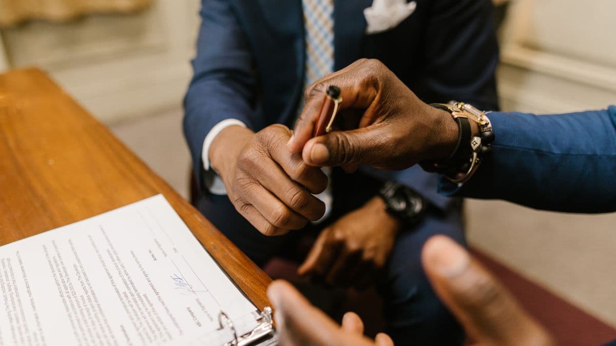Two people finalizing a contract at a desk