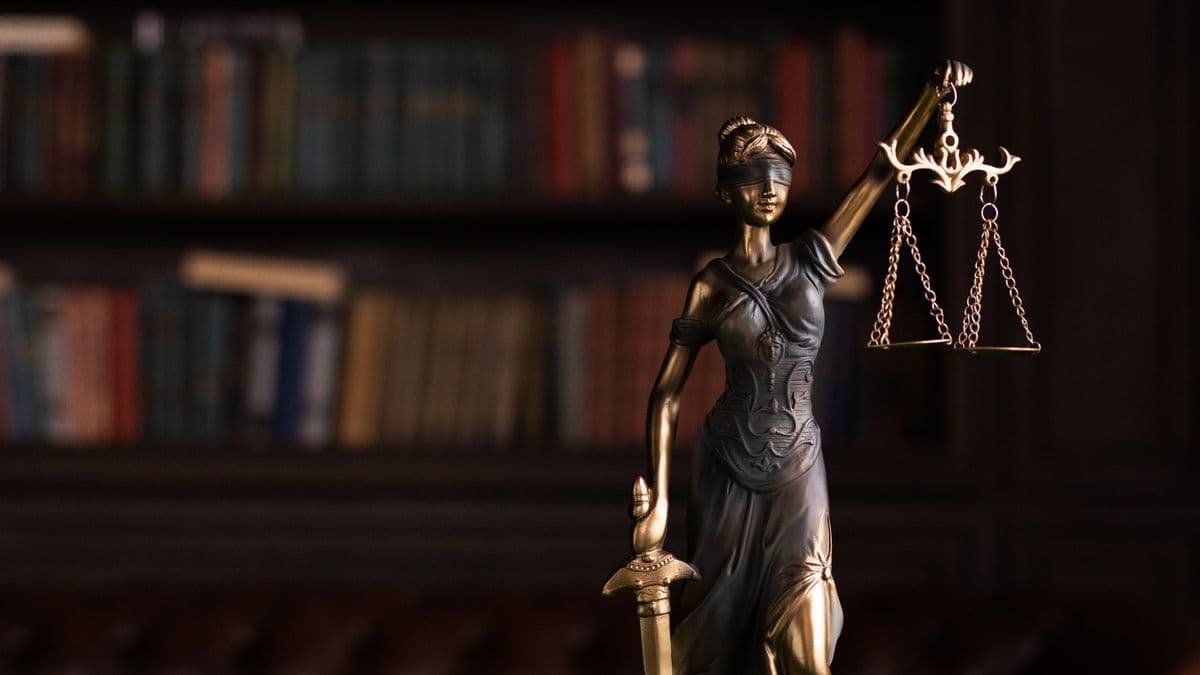 A statue of Lady Justice beside law books